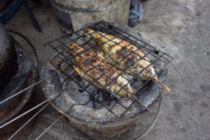 魚の炭焼き。お腹にハーブなどをいっぱい詰めて焼く