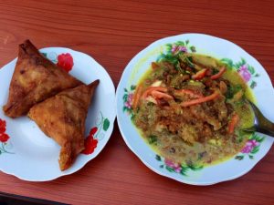 屋台で食べたサモサ（左）と千切り野菜にスープをかけた料理（右）